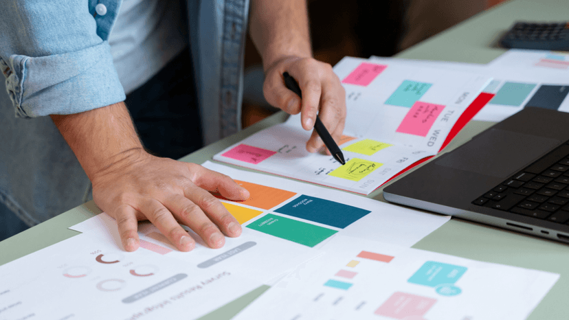 Person's hands pointing at colors on a paper